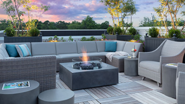 The Wade rooftop terrace at sunset, gas firepit, ipe wood decking, summer classic sofa and chair furniture