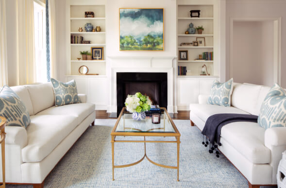 The Wade interiors, traditional living room with all white sofa and styled built-ins with gas fireplace